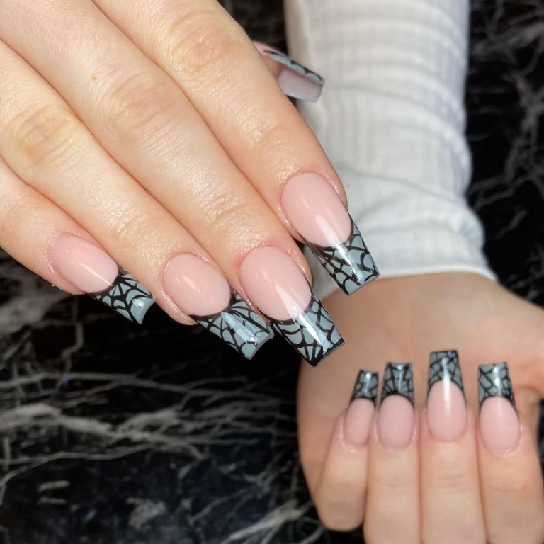 Halloween nails with black spider web painted on grey French tips.